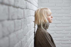 Dziewczyna oparta o mur. Poczucie bezsilności - jak sobie z nim radzić