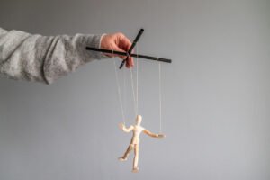 Mężczyzna z marionetką. Czy wiesz, jak bronić się przed manipulacją w związku?