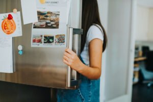 Nastolatka zagląda do lodówki. Zaburzenia odżywiania u nastolatków