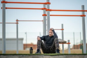 Zawodnik siedzący na murawie. Z czego może wynikać brak wiary w siebie u sportowca
