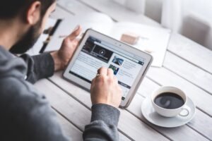 Mężczyzna przeglądający wiadomości na tablecie - Media społecznościowe a zdrowie psychiczne