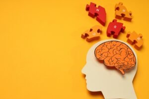 Model głowy człowieka z mózgiem. Obok puzzle - Terapia EMDR jak działa i kiedy warto ją rozważyć