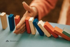 Kobieca dłoń stopująca przewracające się domino - efekt Zeigarnik