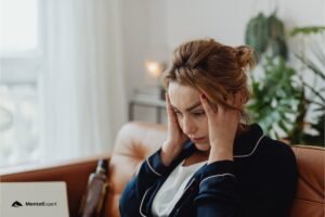 Kobieta trzyma dłonie przy skroni. napięciowe bóle głowy emocje